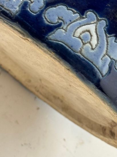 Circular ceramic umbrella stand on a blue...