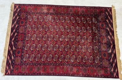 CHIRAZ.
Tapis mécanique sur fond rouge à...
