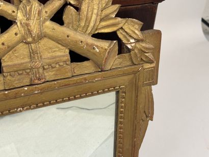 Miroir en bois doré à décor d'attributs de...