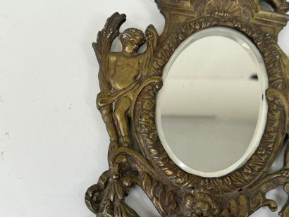 Miroir en bronze ciselé figurant deux angelots,...