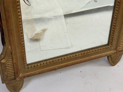 Miroir en bois doré à décor d'attributs de...