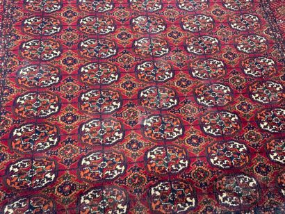 CHIRAZ.
Tapis mécanique sur fond rouge à...