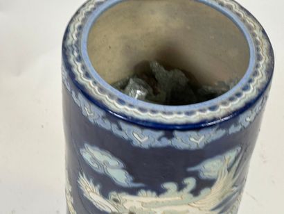 Circular ceramic umbrella stand on a blue...