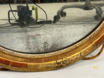 Oval wood and gilded stucco mirror decorated...