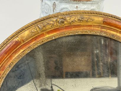 Oval wood and gilded stucco mirror decorated...