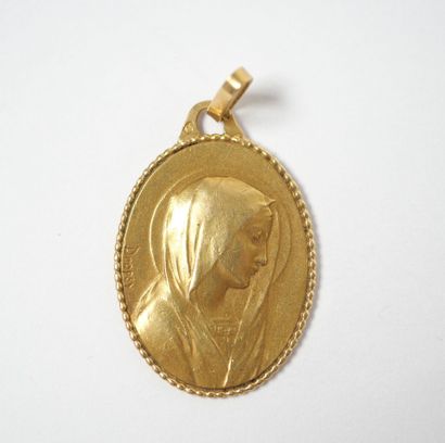 Oval religious medal in 18K yellow gold depicting...