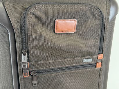 TUMI.
Valise roulante cabine en toile marron.
53...