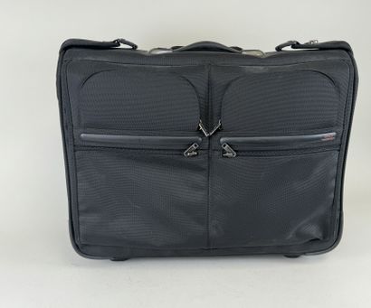 TUMI.
Valise roulante en toile noire.
48...