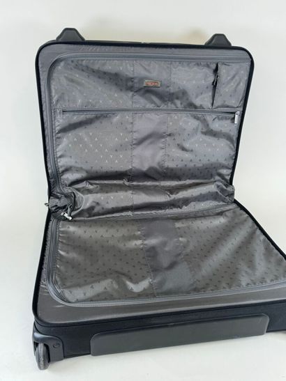 TUMI.
Valise roulante en toile noire.
48...