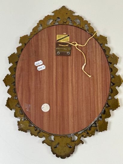 Oval brass mirror decorated with foliage...