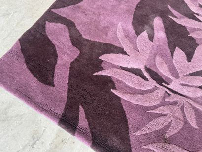 Large woollen rug on a violet ground, decorated...