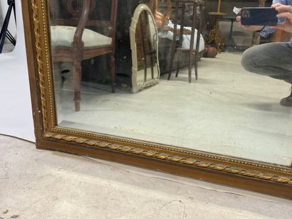 Large mirror in wood and gilded stucco, the...