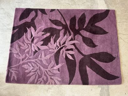Large woollen rug on a violet ground, decorated...