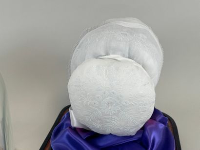 Coiffe en dentelle brodée.
Présentée sous...