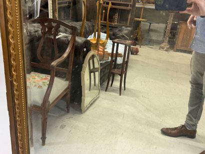 Large mirror in wood and gilded stucco, the...