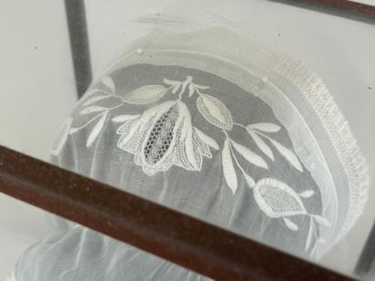 Coiffe en dentelle brodée.
Présentée dans...