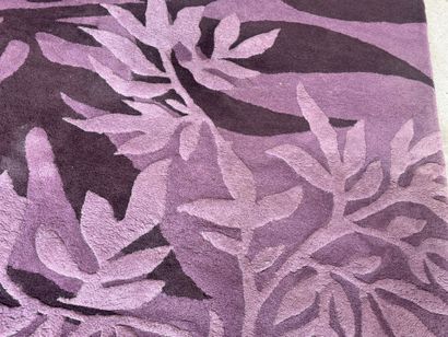 Large woollen rug on a violet ground, decorated...
