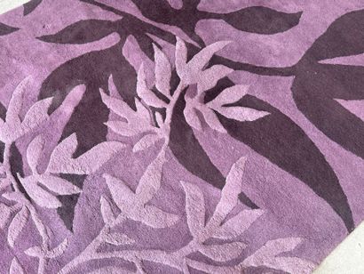 Large woollen rug on a violet ground, decorated...