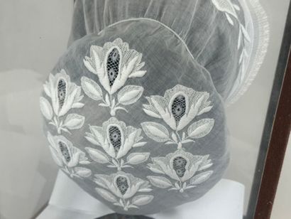 Coiffe en dentelle brodée.
Présentée dans...