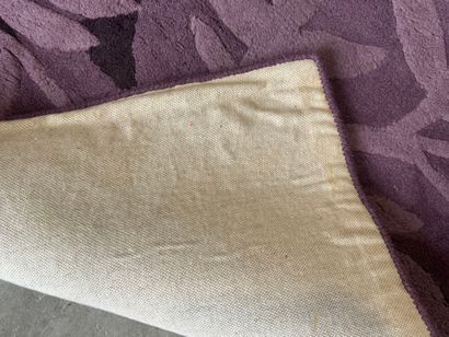 Large woollen rug on a violet ground, decorated...