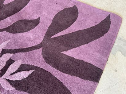 Large woollen rug on a violet ground, decorated...