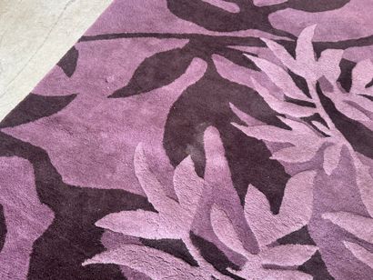 Large woollen rug on a violet ground, decorated...