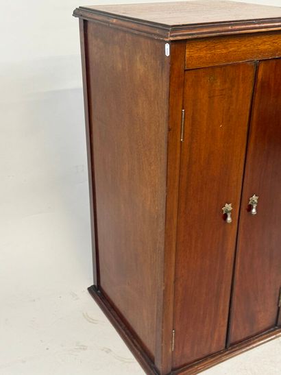 Mahogany cabinet opening with two doors,...