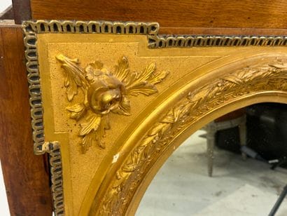 Wood and gilded stucco mirror with oval view,...