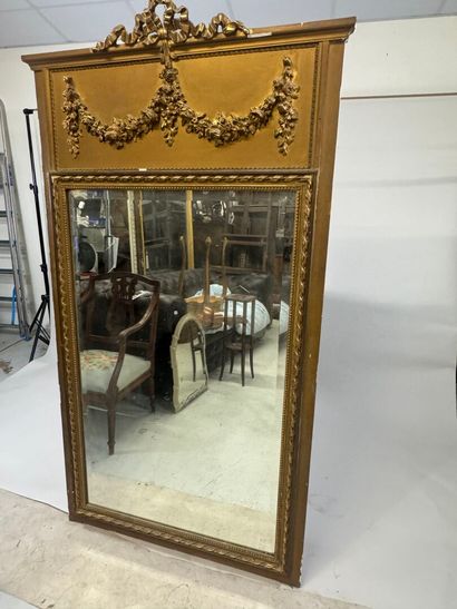 Large mirror in wood and gilded stucco, the...