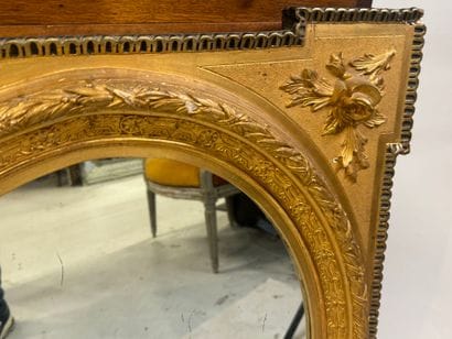 Wood and gilded stucco mirror with oval view,...