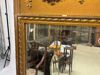 Large mirror in wood and gilded stucco, the...