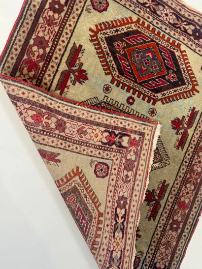 Small hand-knotted wool rug with stylized...