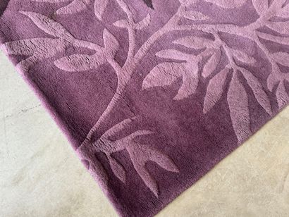 Large woollen rug on a violet ground, decorated...
