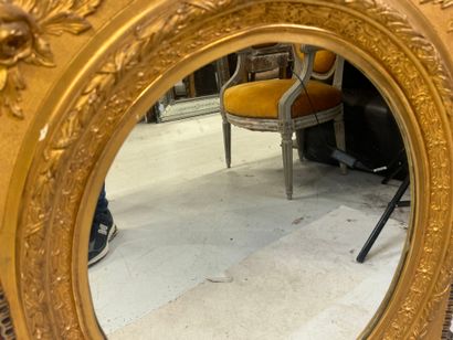 Wood and gilded stucco mirror with oval view,...