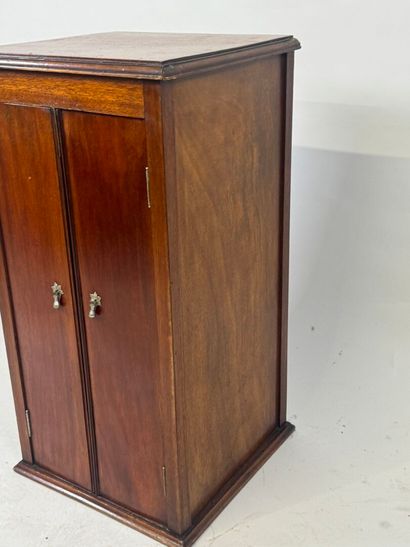 Mahogany cabinet opening with two doors,...