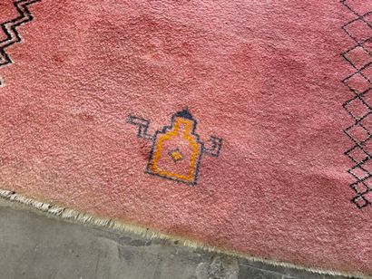 Grand tapis sur fond orangé à décor de motifs...