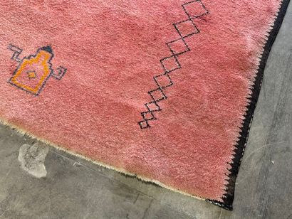 Grand tapis sur fond orangé à décor de motifs...