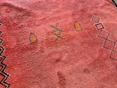 Grand tapis sur fond orangé à décor de motifs...