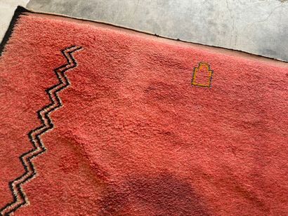Grand tapis sur fond orangé à décor de motifs...
