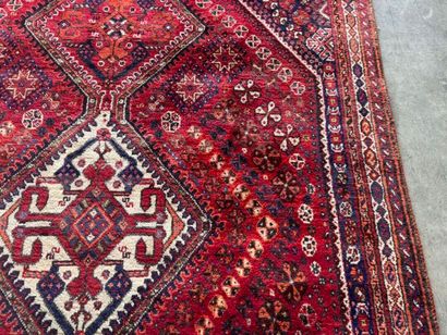 Grand tapis en laine noué main sur fond rouge...