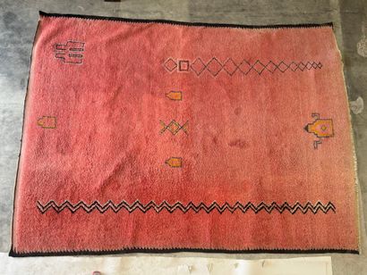 Grand tapis sur fond orangé à décor de motifs...