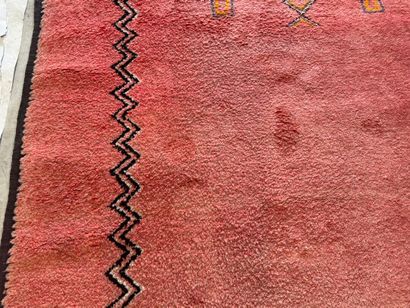Grand tapis sur fond orangé à décor de motifs...