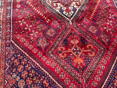 Grand tapis en laine noué main sur fond rouge...