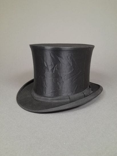 Black satin hat adorned with matching grosgrain...