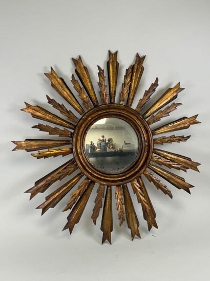 Radiating mirror in carved and gilded wood...