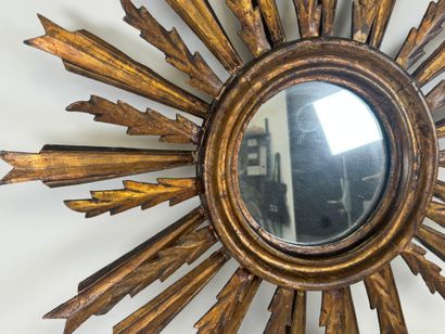 Radiating mirror in carved and gilded wood...