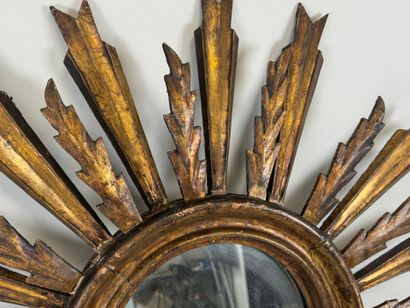 Radiating mirror in carved and gilded wood...