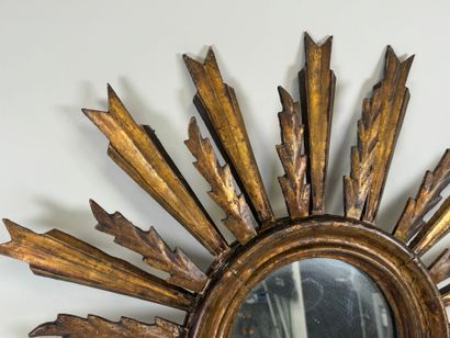 Radiating mirror in carved and gilded wood...
