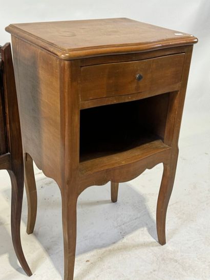 Two wooden bedside tables, one with curtain...