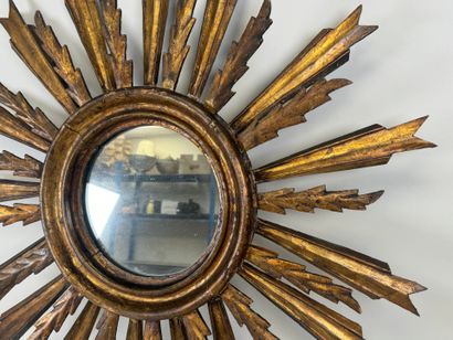 Radiating mirror in carved and gilded wood...